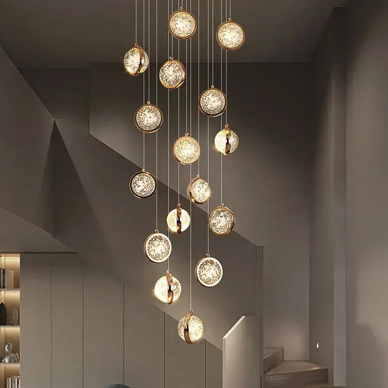 Modern gold crystal ball chandelier with multiple warm glowing glass orbs on a metallic frame for staircase lighting