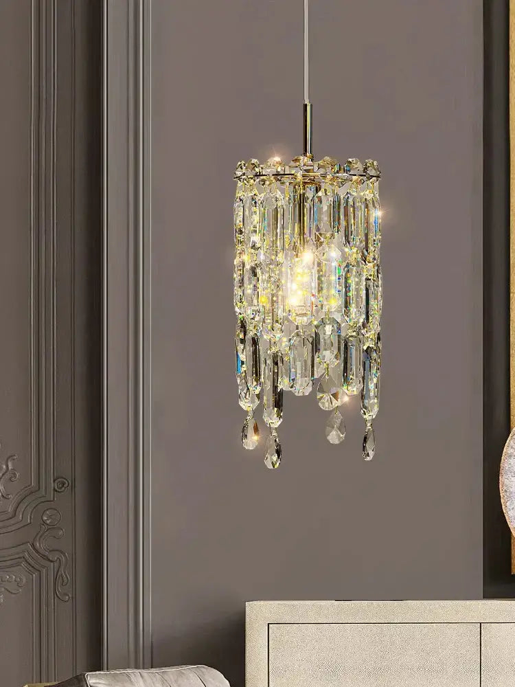Modern gold crystal bedhead pendant light featuring a sparkling gold-toned chandelier with faceted glass prisms
