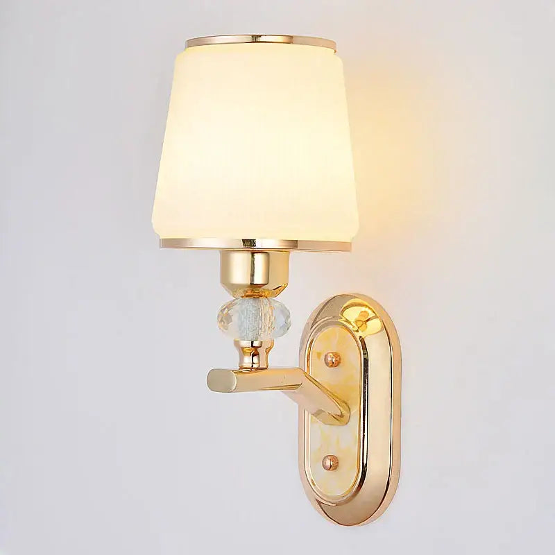 Modern gold bedside wall sconce with frosted glass shade and ornate crystal accent for bedroom lighting