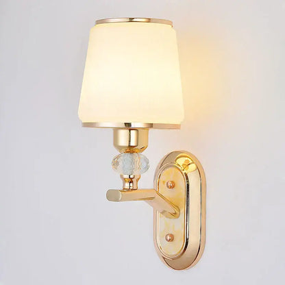 Modern gold bedside wall sconce with frosted glass shade and ornate crystal accent for bedroom lighting