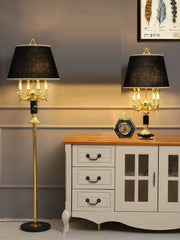 Modern gold crystal black table lamp featuring a gold-finished chandelier style with black textured shade and candle bulbs