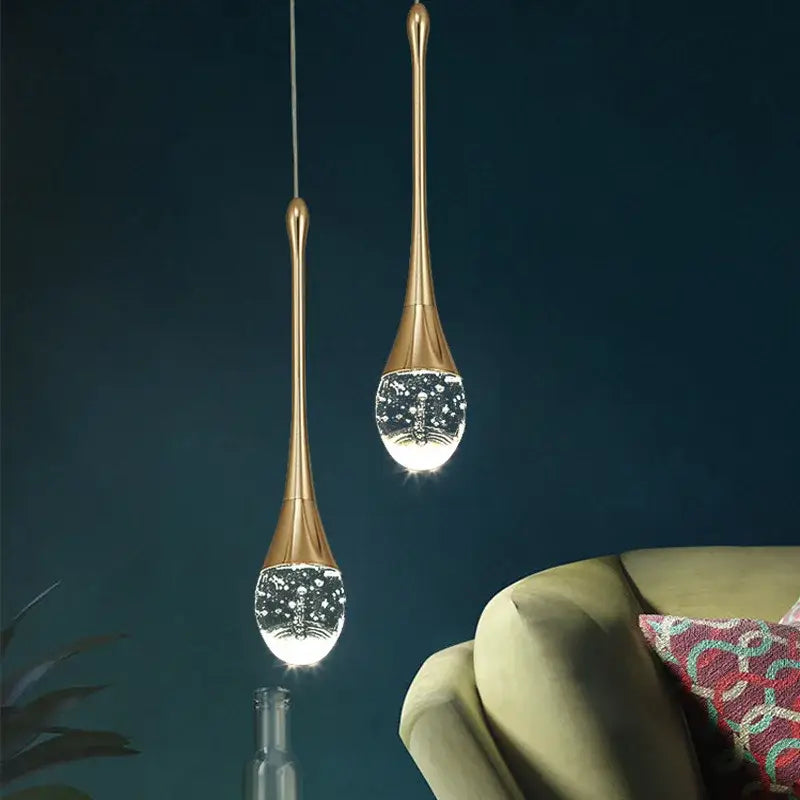 Two elegant gold-toned decorbites crystal bubble pendant lights with teardrop crystal globes for modern dining room decor
