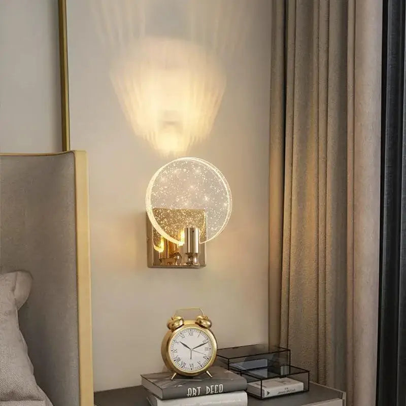 A modern gold crystal bubble wall lamp with a translucent glass globe emitting warm light for luxury bedroom decorbites lighting