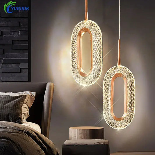 Two elegant oval pendant lights with golden copper metal chassis and intricate crystal mesh cord pendant design