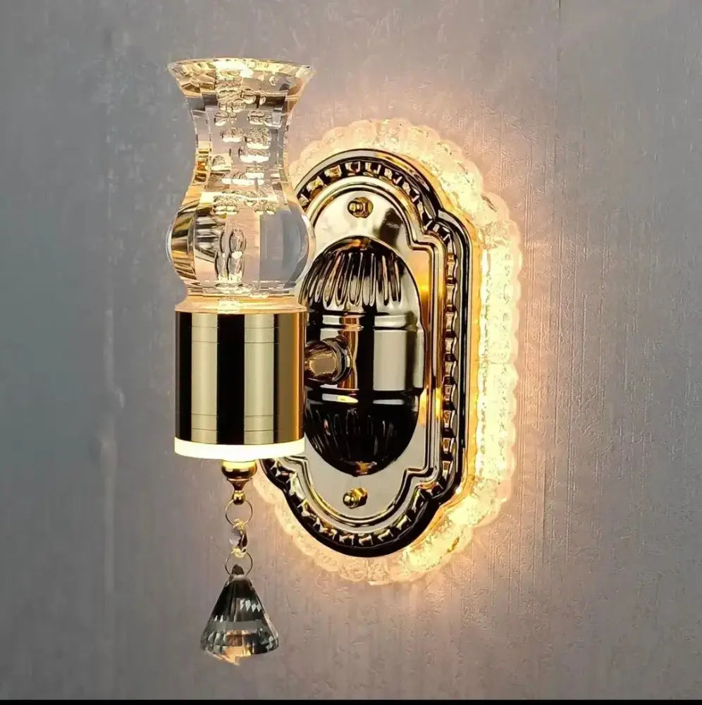 Modern gold wall light with decorbites carved flower design featuring a crystal vase-shaped lampshade and pendant