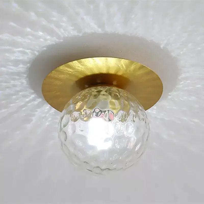 Modern clear textured glass globe crystal ceiling light with hammered gold-toned metal base for bedroom use