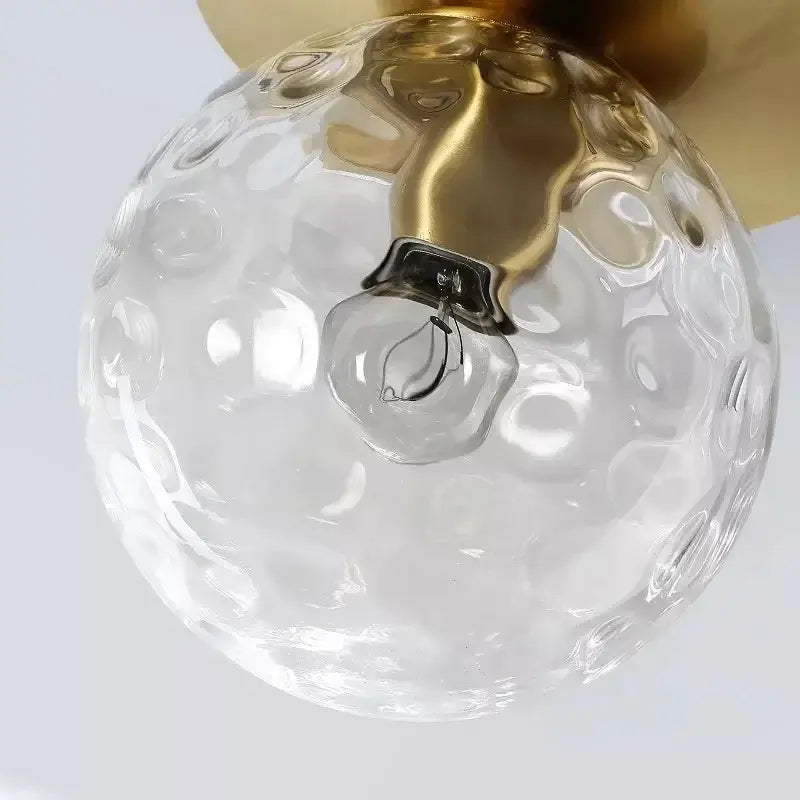 Modern gold crystal ceiling light with a clear hammered glass globe and gold-toned metal fixture for bedroom use