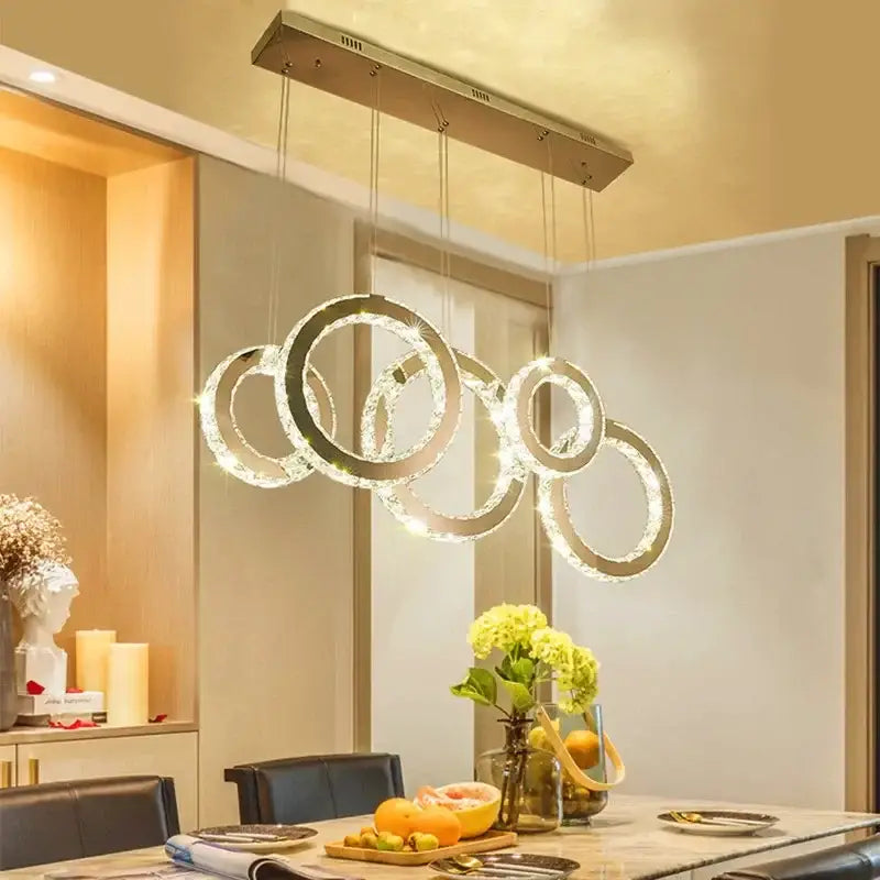 Modern gold crystal circle led pendant chandelier with interlocking crystal rings suspended from metallic bar