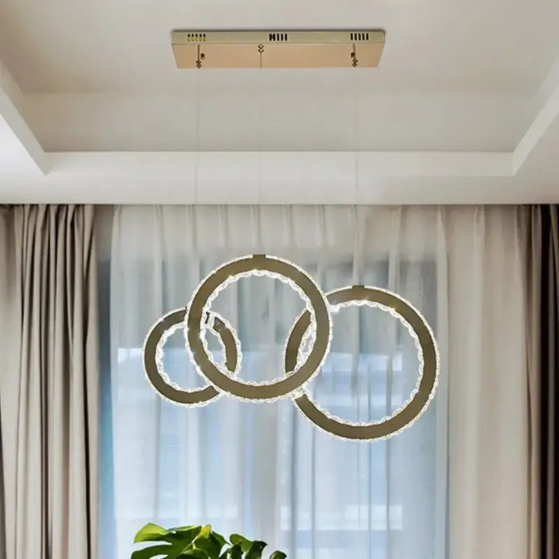 Modern gold crystal circle led pendant chandelier with three interlocking rings and sparkling crystal accents for dining room decorbites