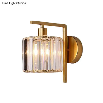 Modern gold wall sconce featuring a cylindrical crystal column shade with vertical facets for bedroom lighting
