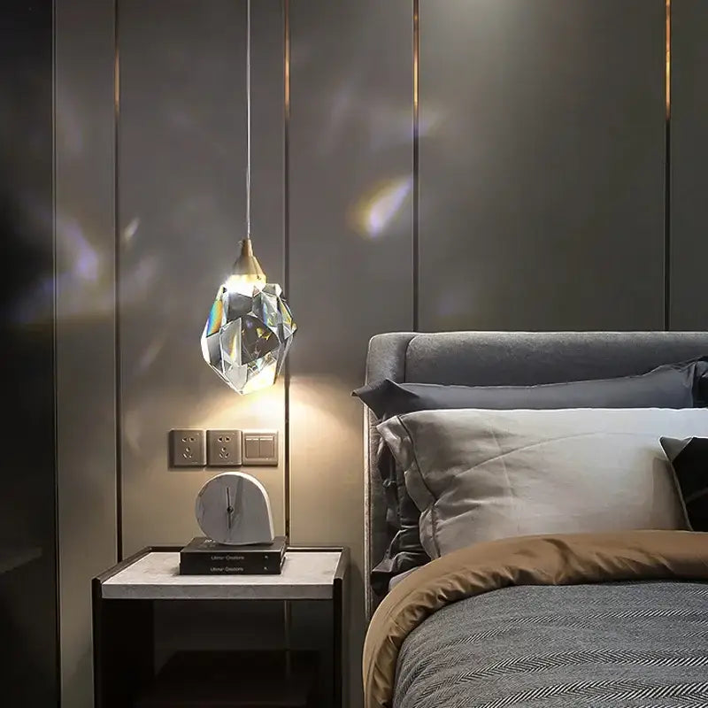 A faceted decorbites k9 crystal dining chandelier with a gold-toned top hangs, casting warm crystal dining light
