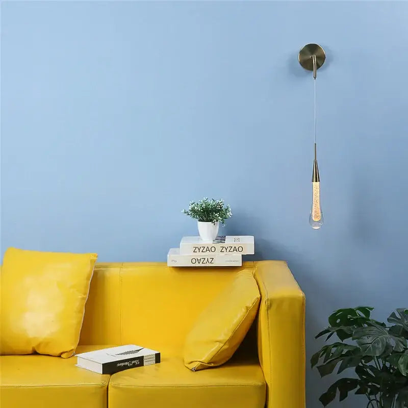A modern gold crystal droplet wall lamp with a metallic fixture and amber bead-filled glass shade for living room decorbites crystal droplet wall sconce