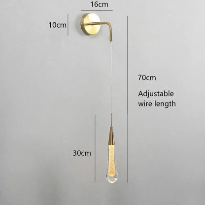 Modern gold crystal droplet wall lamp with a gold-toned brass sconce and dangling crystal droplet filled with golden liquid