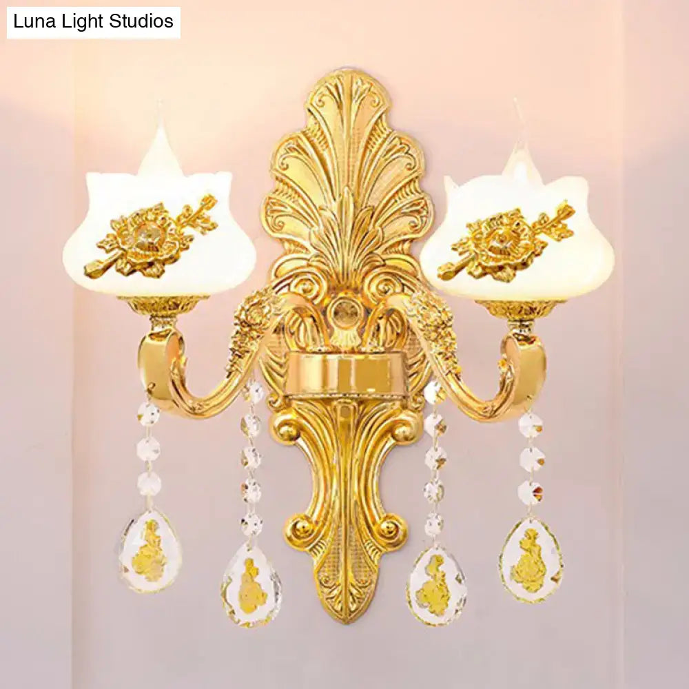 Modern gold crystal droplet wall mount light with ornate gold floral details and frosted glass shades for bedroom use