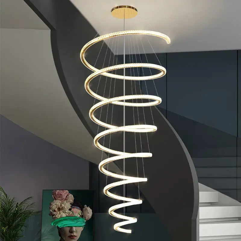 Modern gold crystal duplex ring pendant light with glowing spiral rings and sleek metallic gold-toned ceiling mount