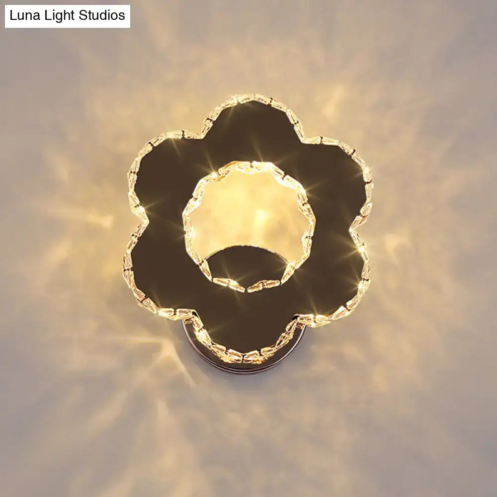 A modern gold crystal flower wall sconce with sleek black chrome finish and warm white light 110v-120v for bedroom use