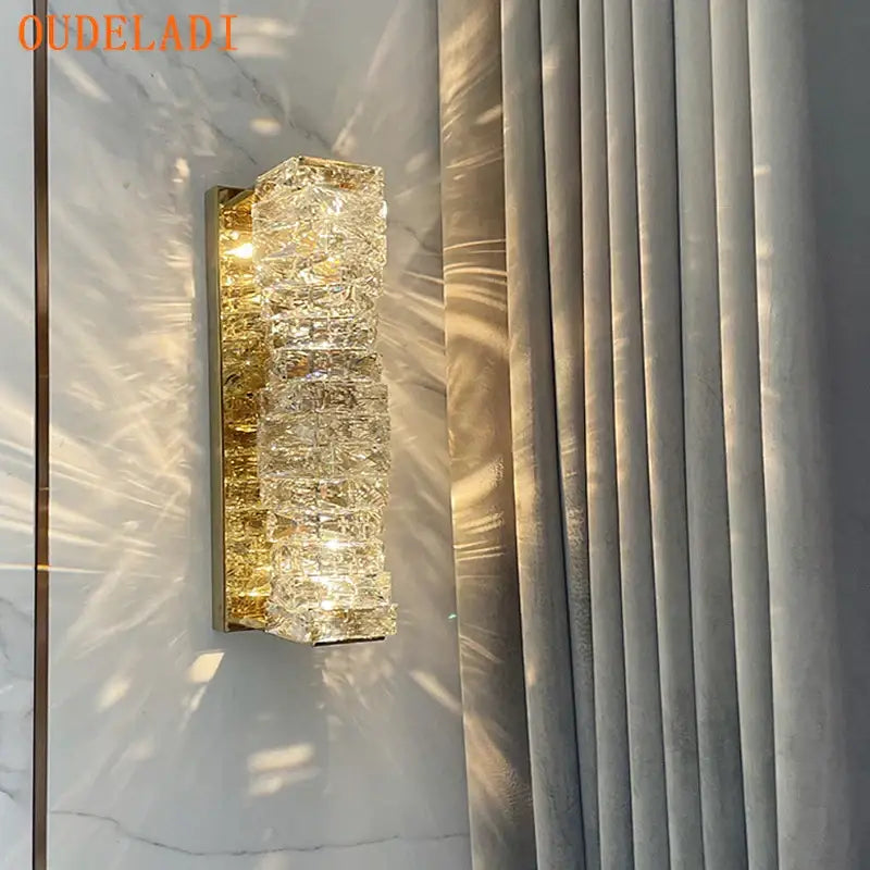 Modern gold crystal glass wall sconce with stacked faceted crystals emitting warm glow for bedroom decorbites crystal glass lighting