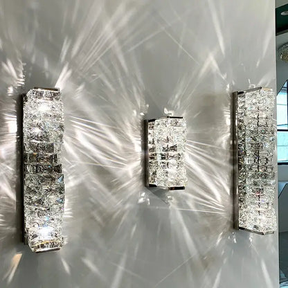 Three modern gold crystal glass wall sconces with sleek rectangular metallic frames for warm bedroom decorbites light