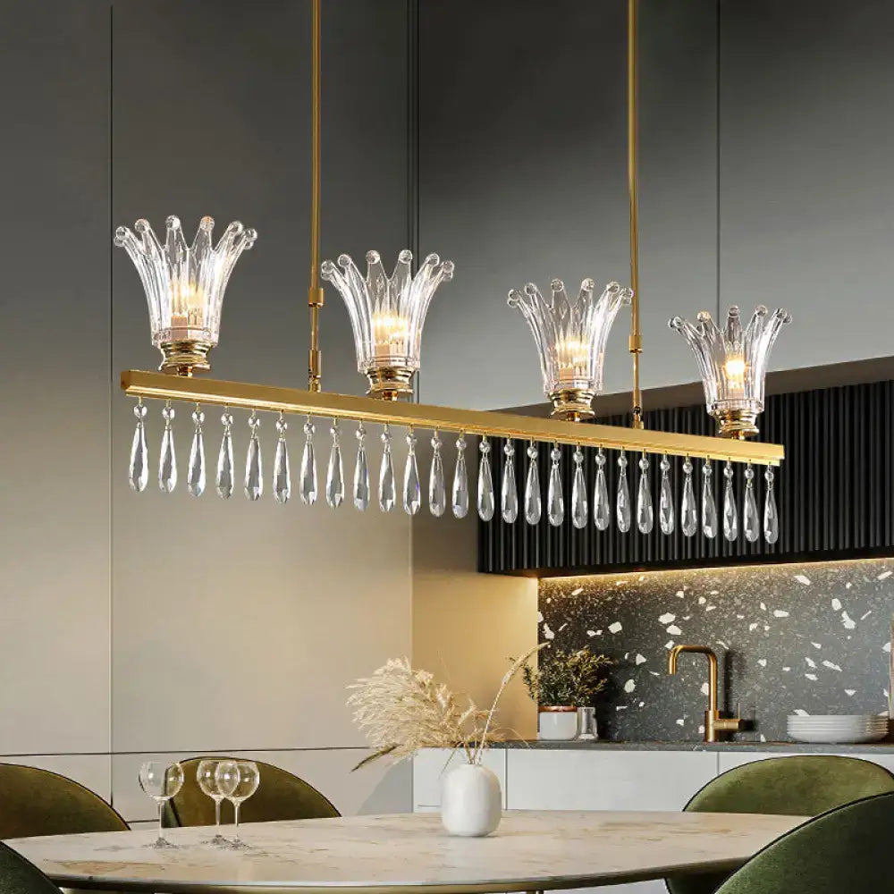 Gold-toned rectangular DecorBites island light with four crown crystal shades and dangling teardrop crystals ceiling light fixture