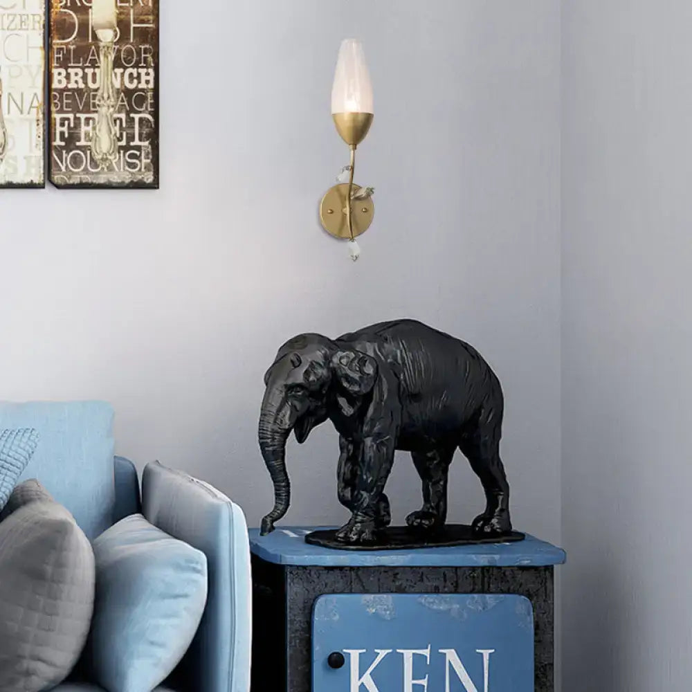 Black matte-finished elephant sculpture with detailed texture on dark base complements modern gold finish crystal leaf design
