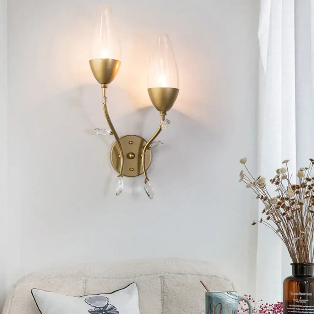 Modern gold crystal leaf wall sconce with gold finish and clear crystal leaf design featuring two candle-style bulbs