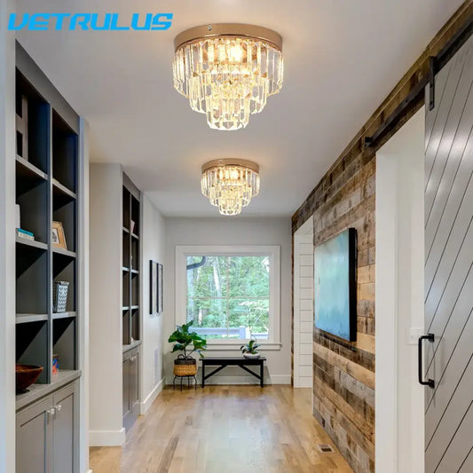 Two elegant modern gold crystal led ceiling chandeliers with cascading clear faceted crystals for dining room