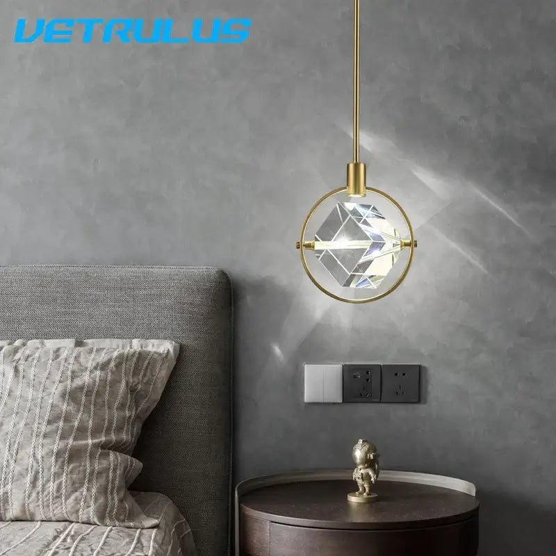 A modern gold brass pendant light with a faceted crystal globe in a circular frame for decorbites crystal led ceiling use