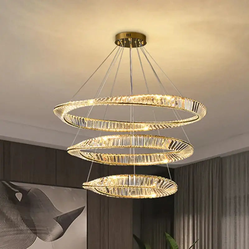 Modern gold crystal led chandelier with three concentric spiraling rings and faceted crystals by decorbites crystal led