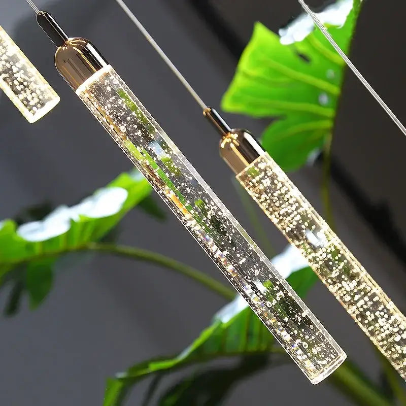 Modern gold crystal led chandelier with clear cylindrical pendant lights and glowing bubbles by decorbites crystal led