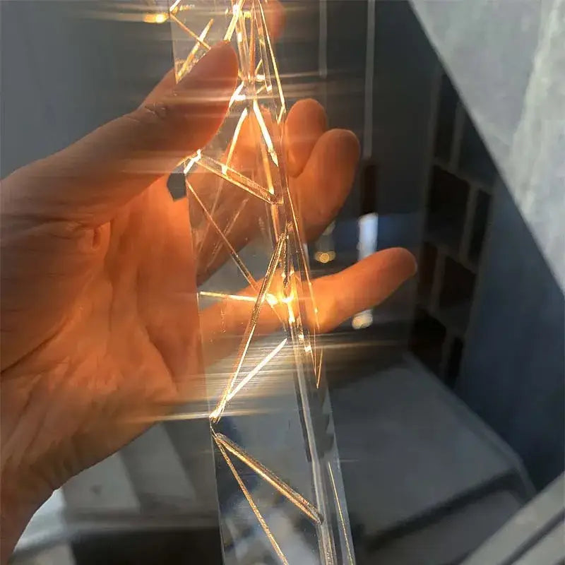 A hand holds a modern gold crystal led chandelier with warm lights showcasing decorbites crystal led design