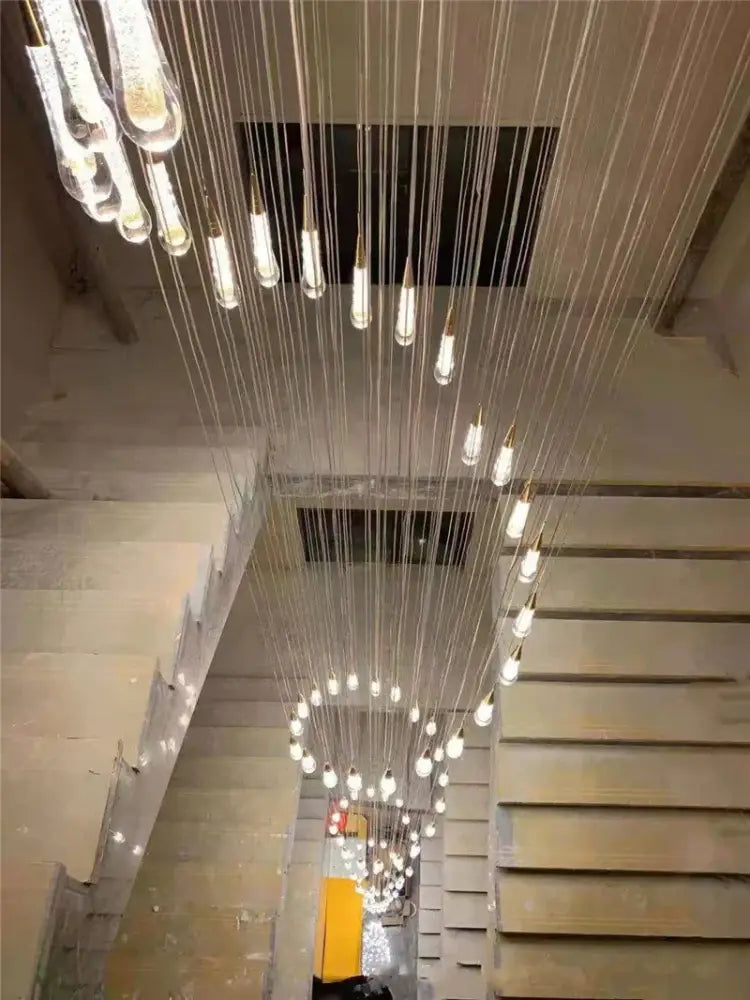 Modern gold crystal led chandelier with cascading clear crystal teardrop pendants and frosted glass bulbs by decorbites crystal led