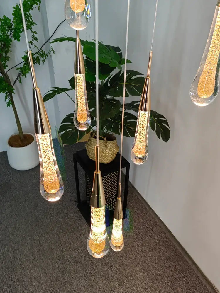 Modern gold crystal led pendant chandelier with elegant gold-toned crystal led pendant lights featuring amber liquid interiors