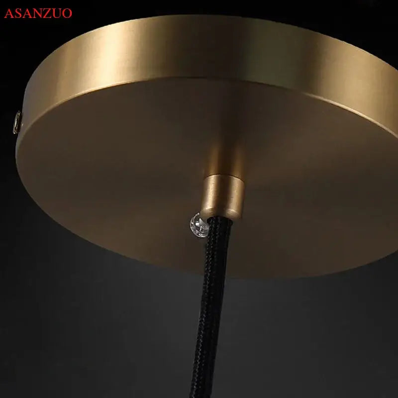 Modern brass-finished circular pendant light with black braided cord and clear crystal accent for bedroom decorbites crystal led