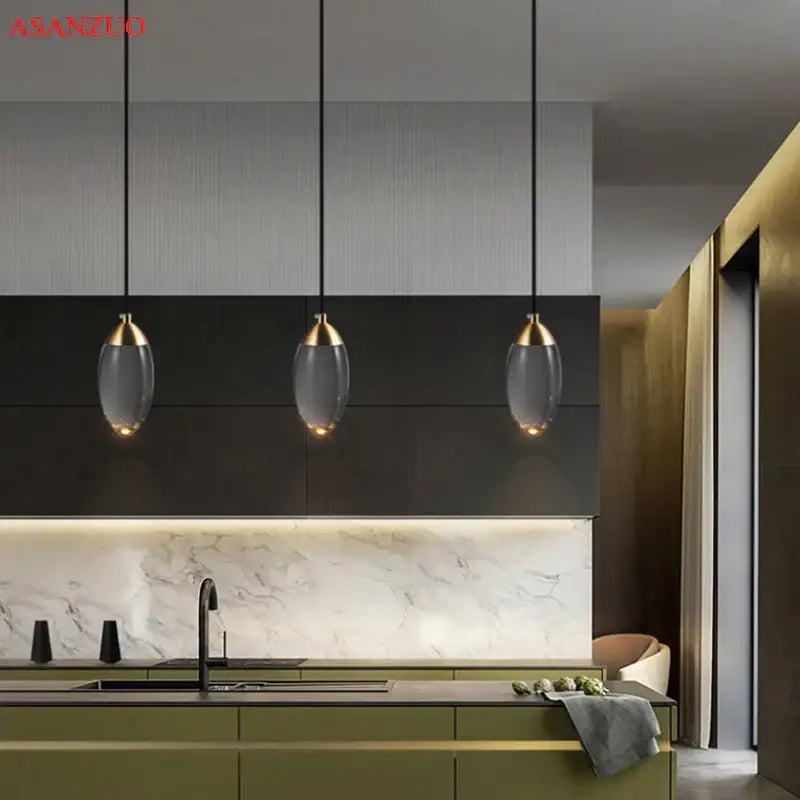Three elegant modern gold crystal led pendant lights with glass shades hang above a kitchen island decorbites crystal led