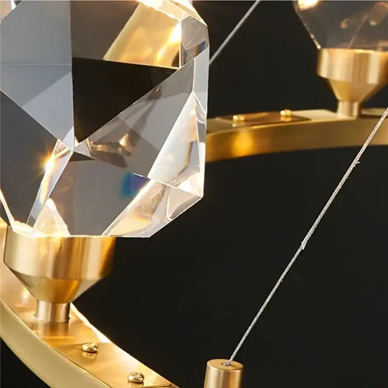 Modern gold crystal led pendant lights featuring a faceted crystal chandelier pendant with a polished gold-toned base
