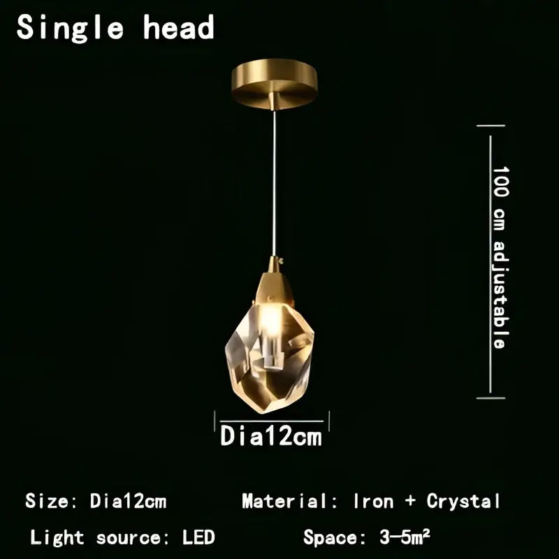 A modern gold crystal led pendant light with a faceted globe hanging from an iron fixture for dining rooms