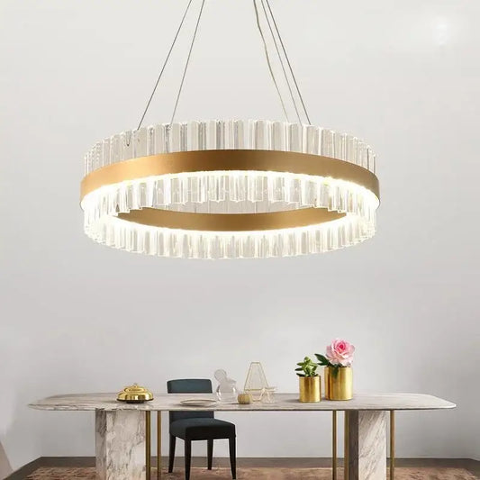 A modern gold crystal led ring chandelier with a metal frame and clear prisms for elegant dining room decorbites