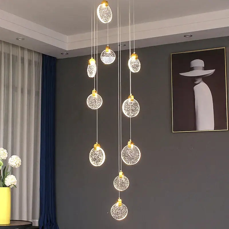 A modern gold crystal led stair pendant light featuring spherical glass orbs with warm illuminated decorbites crystal led