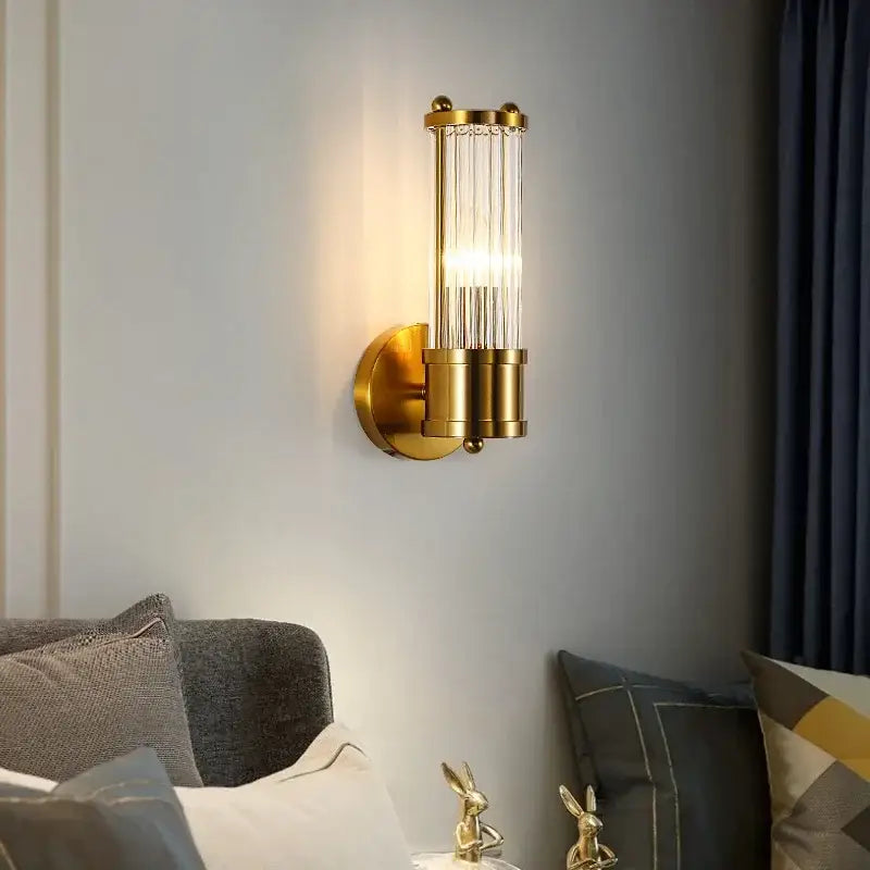 Modern gold crystal led wall lamp with vertical glass rods and cylindrical brass base for elegant bedroom decorbites crystal led design