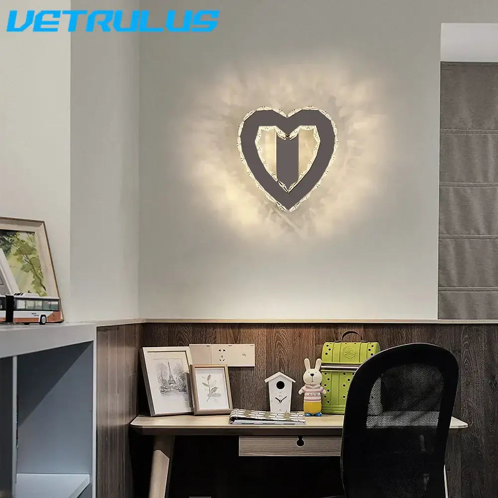 A modern gold decorbites crystal led wall lamp with a black frame and sparkling accents emitting a warm glow