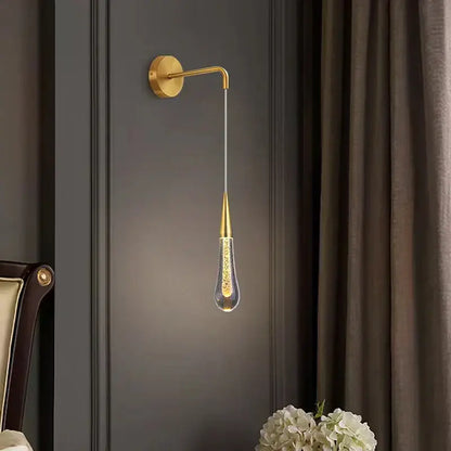 Gold-toned modern wall lamp with teardrop glass pendant and golden speckles in decorbites crystal led wall design