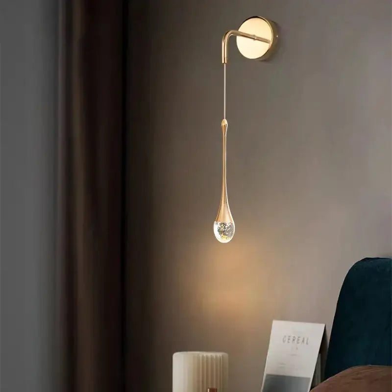 Modern gold crystal led wall lamp featuring a sleek teardrop-shaped crystal pendant for elegant bedroom decorbites crystal led lighting