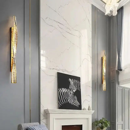 Modern gold crystal led wall lamp with textured gold-toned design flanks white marble fireplace for luxury decorbites crystal led lighting