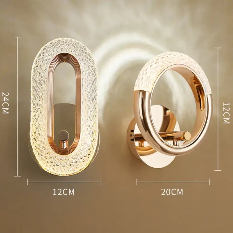 Two modern led wall lamps with oval and circular textured crystal shades and rose gold metal frames for living room use
