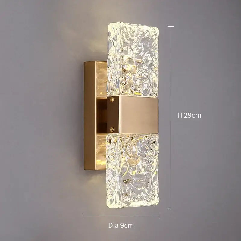Modern gold crystal led wall sconce with clear textured glass panels and gold metal base for bedroom lighting