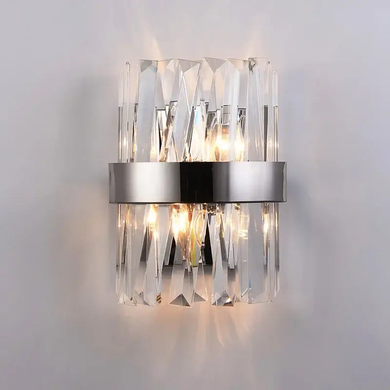 Modern gold led wall sconce with clear crystal prisms and silver metallic band ideal for bedroom lighting