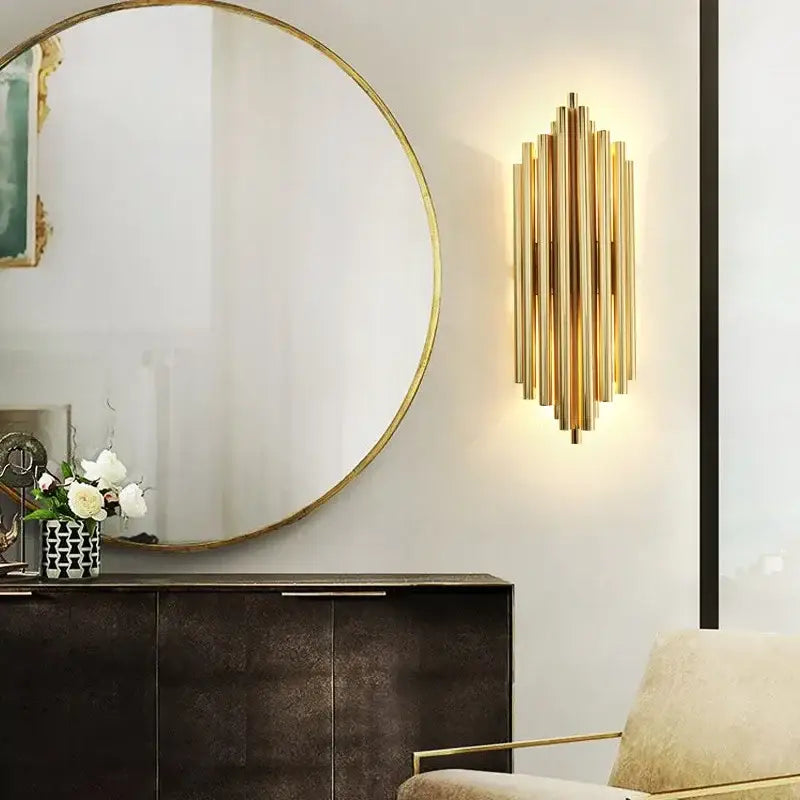 Modern gold crystal led wall sconce featuring vertical brass tubes in a radiant geometric pattern for bedroom lighting
