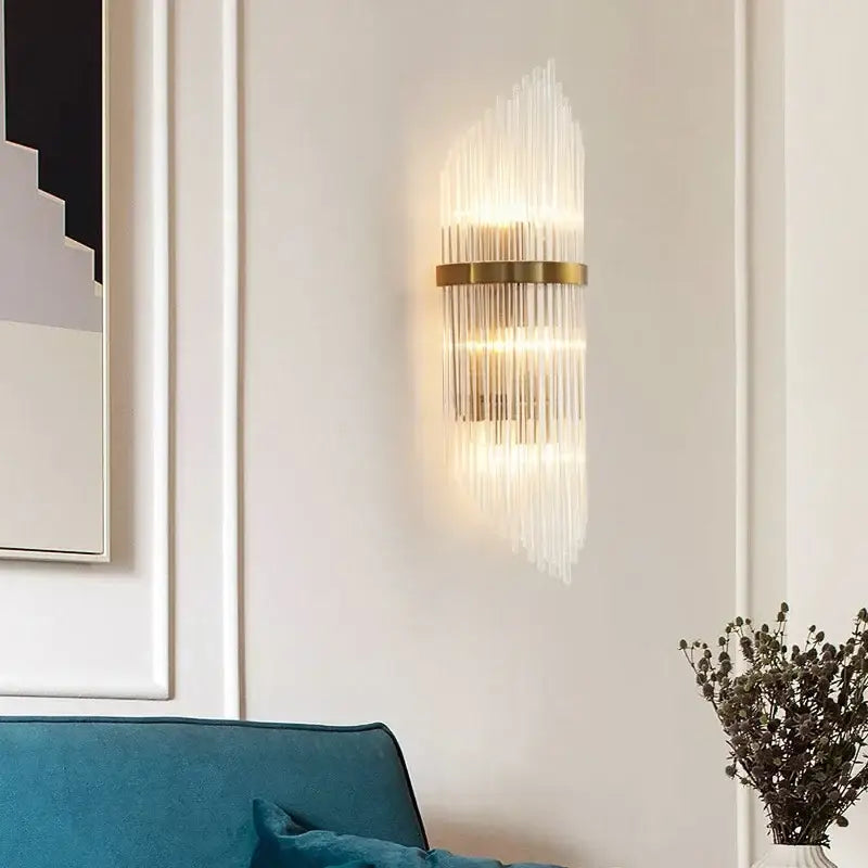 Modern gold crystal led wall sconce with vertical glass rods emitting warm glow for bedroom lighting