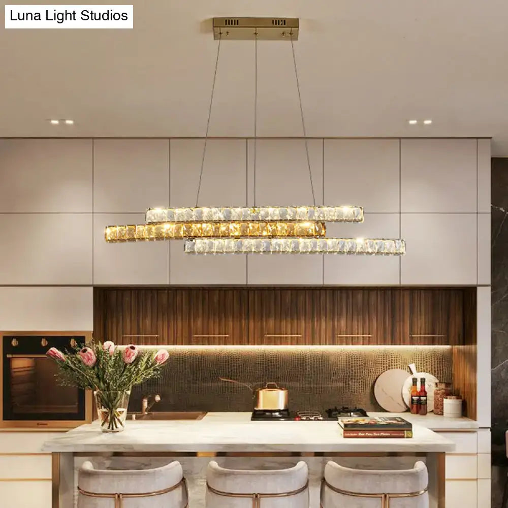 Decorbites gold linear island pendant light with crystal accents and gold-toned linear island light above kitchen island