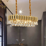 DecorBites gold crystal chandelier with cylindrical brass arms and crystal droplets for elegant oval dining room lighting
